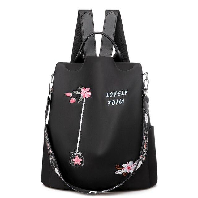 Sac à dos noir élégant avec broderie florale rose, texte "Lovely FDM", bretelles ajustables et poignée supérieure. Accessoire mode femme tendance.
