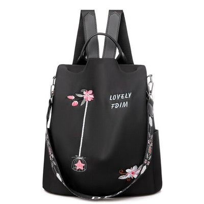 Sac à dos noir élégant avec broderie florale rose, texte "Lovely FDM", bretelles ajustables et poignée supérieure. Accessoire mode femme tendance.