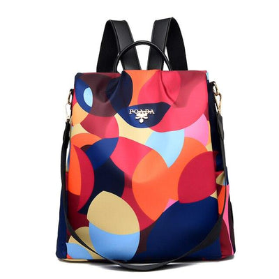 Sac à dos coloré avec motifs géométriques multicolores, logo visible. Design moderne, idéal pour la mode urbaine et les sorties décontractées.