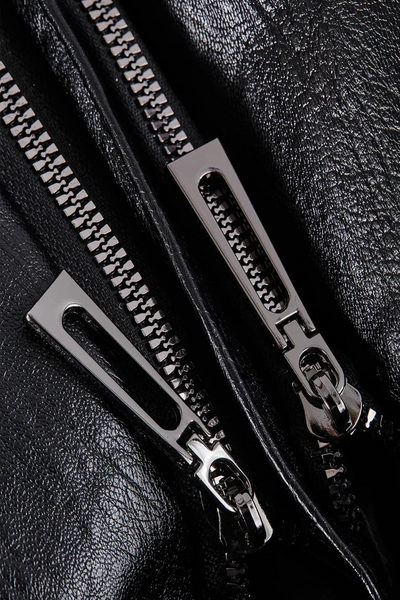 Gros plan sur une fermeture éclair métallique double sur un blouson en cuir noir, texture brillante. Mode, accessoires, vêtements en cuir.