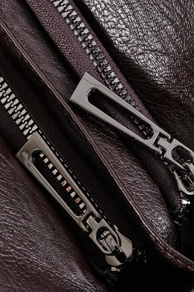 Gros plan sur une fermeture éclair métallique sur cuir marron foncé, texture luxueuse, accessoires de mode, détails de sac en cuir élégant.