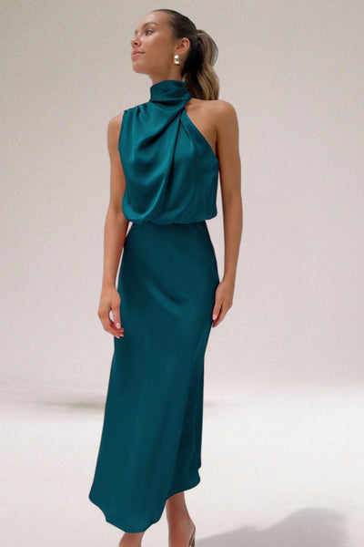 Robe élégante en satin vert émeraude, col haut, sans manches, portée par une femme. Mode chic, tenue de soirée, style moderne.