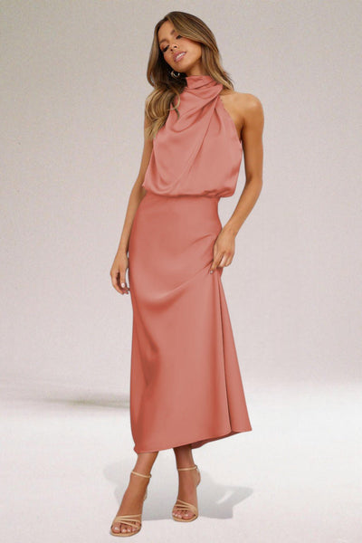 Robe longue rose élégante avec col drapé, portée par une femme posant sur fond neutre. Mode féminine, tenue de soirée chic, style moderne.
