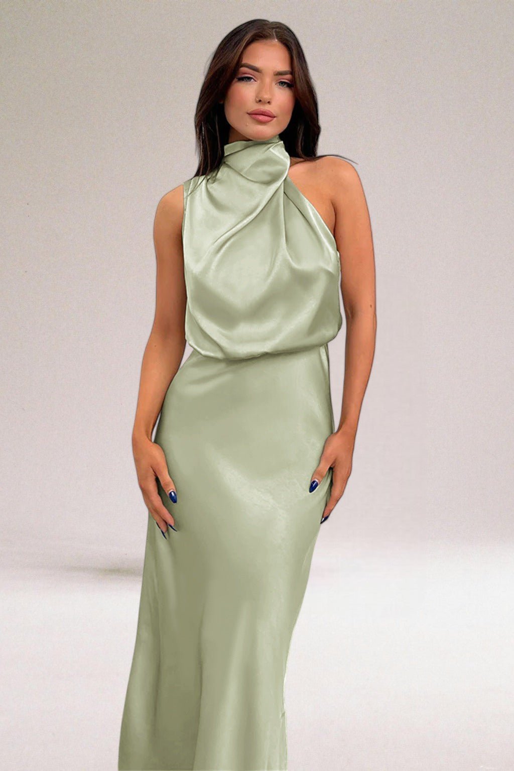 Robe élégante en satin vert clair, sans manches, avec col drapé, portée par une femme sur fond neutre. Mode féminine, tenue de soirée chic.