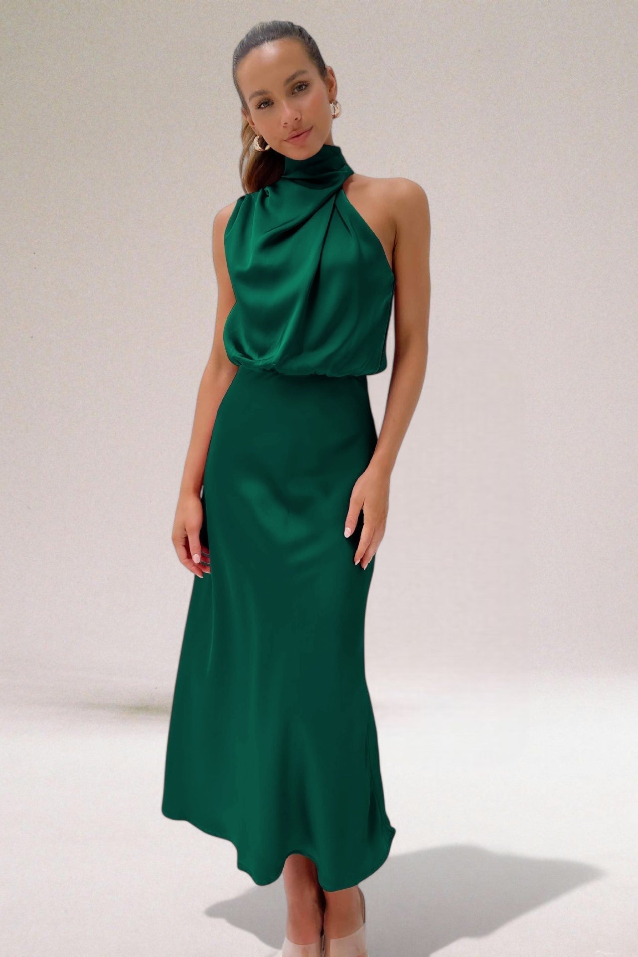 Robe élégante verte, sans manches, col haut, portée par une femme. Mode féminine, tenue de soirée chic, style moderne.
