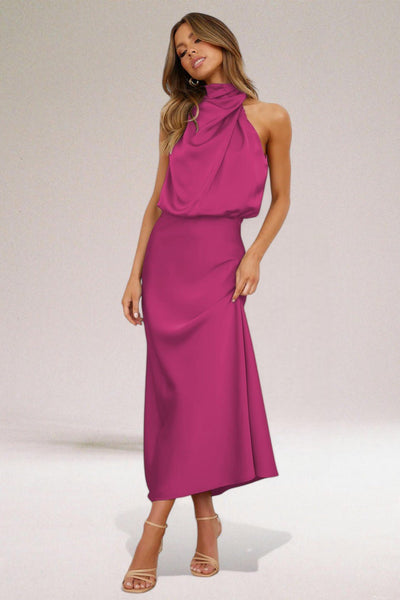 Robe longue fuchsia élégante, sans manches, col drapé, portée par une femme. Mode féminine chic, tendance soirée, style glamour.