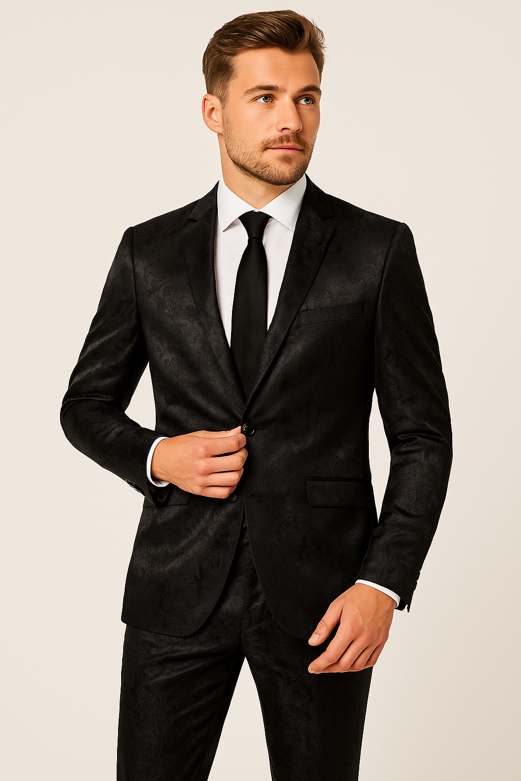 Homme en costume noir élégant avec cravate, posant sur fond neutre. Mode masculine, tenue formelle, style sophistiqué.