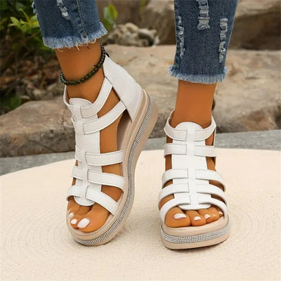 Sandales blanches à plateforme pour femme, style gladiateur, portées avec un jean déchiré. Chaussures d'été tendance, confortables et élégantes.