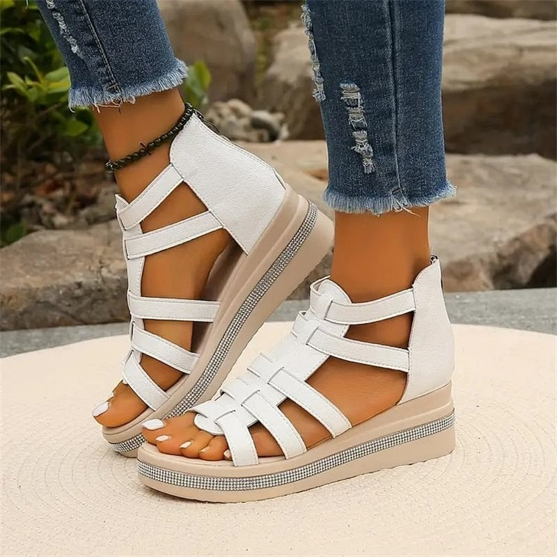 Sandales blanches à plateforme pour femme, style gladiateur, portées avec un jean déchiré. Chaussures d'été tendance, confortables et élégantes.