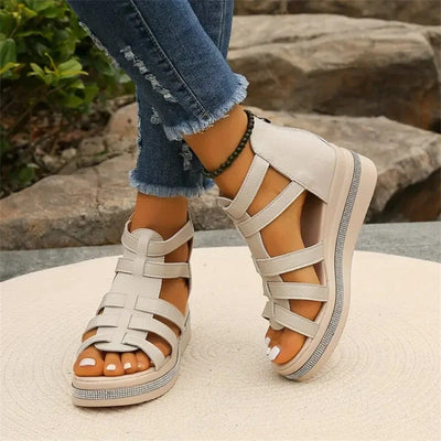 Sandales compensées blanches pour femme, style gladiateur, portées avec un jean déchiré. Mode estivale, chaussures tendance, confort et élégance.