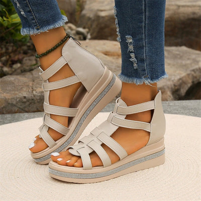 Sandales compensées beiges pour femme, avec lanières croisées, portées avec un jean déchiré. Mode estivale, chaussures tendance, confortables.