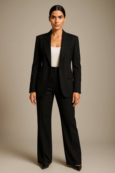 Femme en tailleur noir élégant, veste et pantalon, sur fond neutre. Mode professionnelle, tenue de bureau chic, style moderne.