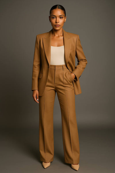 Femme en tailleur pantalon marron élégant, pose professionnelle, fond gris. Mode féminine, tenue de bureau chic, style moderne.
