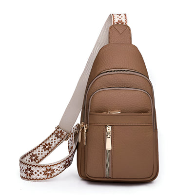 Sac à bandoulière marron en cuir texturé avec fermeture éclair dorée et sangle décorative blanche et marron. Accessoire mode pratique et élégant.