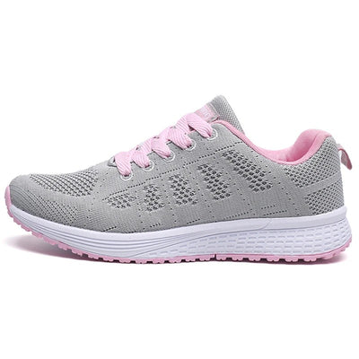 Basket de course grise et rose pour femme, semelle blanche antidérapante, lacets roses, design respirant, idéale pour sport et fitness.