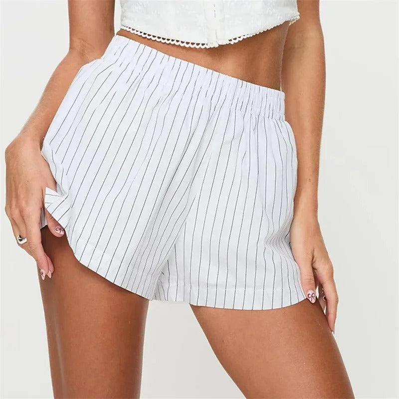 Short en tissu rayé blanc et noir, taille élastique, porté par une femme. Mode estivale décontractée, style moderne et confortable.