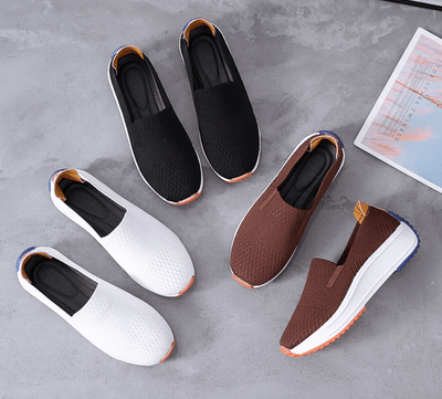 Chaussures slip-on décontractées pour hommes en noir, blanc et marron, semelles antidérapantes, sur fond gris avec magazine.