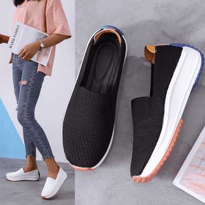 Chaussures décontractées en toile noire et blanche pour femmes, semelle antidérapante, portées avec un jean déchiré et un haut rose.
